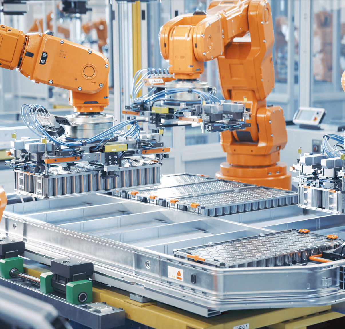 Robotic arms assembling battery packs on an automated production line