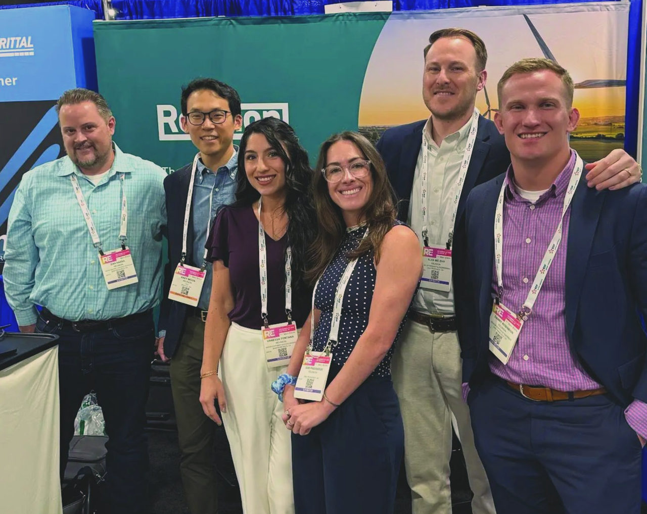 Six members of the Reunion team standing together at a conference booth